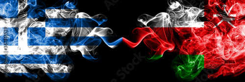 Greece vs Oman, Omani smoky mystic flags placed side by side. Thick colored silky abstract smoke flags.