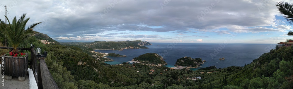 Spectacular panoramic view of Palaiokastritsa village and beach with its harbor during the midday on. Corfu, Greece.