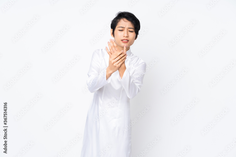 Young Vietnamese woman with short hair wearing a traditional dress over isolated white background suffering from pain in hands Young Vietnamese woman with short hair wearing a traditional dress over isolated white background suffering from pain in hands