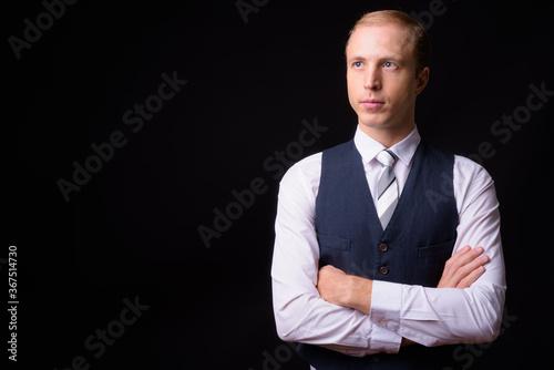Businessman with blond hair against black background © Ranta Images