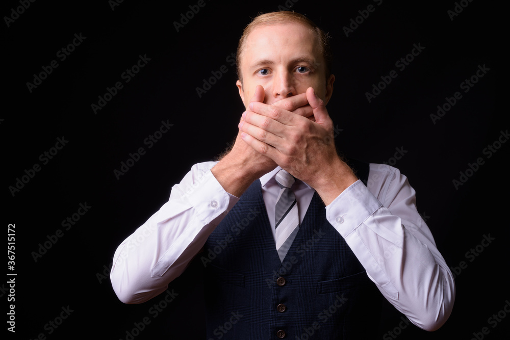 Businessman with blond hair against black background Businessman with blond hair against black background