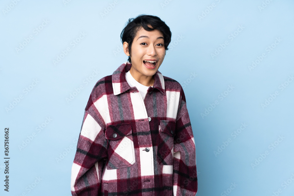 Young Vietnamese woman with short hair over isolated background with surprise facial expression