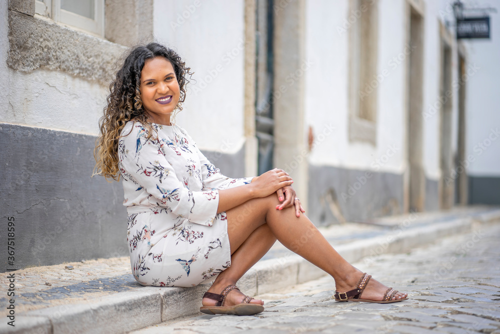 Fototapeta premium Beautiful woman sitting on the pavement
