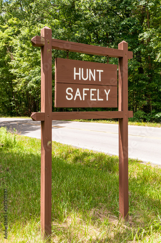 A hunt safely sign on the side of State Route 62 in Venango County, Pennsylvania, USA on a sunny summer day. 