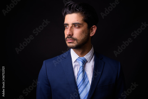 Young handsome bearded Persian businessman against black background © Ranta Images