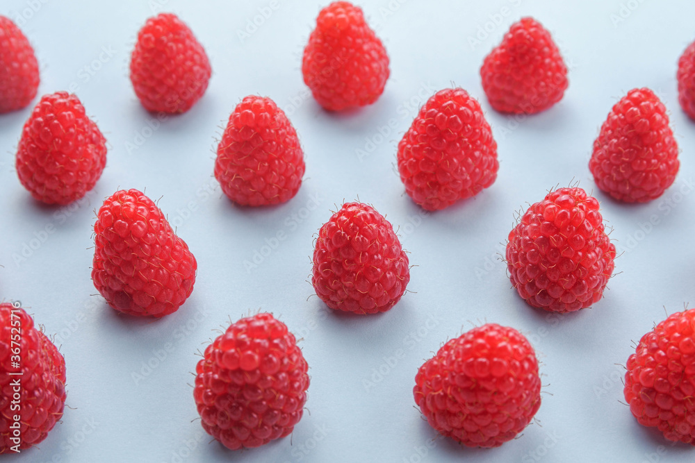 Pattern of raspberry on blue background. Flat lay summer berries - red raspberries. Creative minimalism