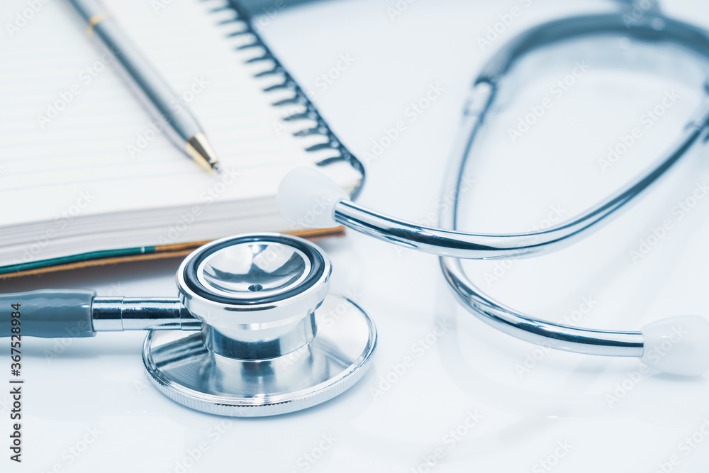 Medical stethoscope for doctor checkup and notepad on table Medical stethoscope for doctor checkup and notepad on table