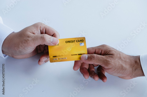 The hands of two businessmen are exchanging Kad credit cards for each other. The concept of spending money online. photo