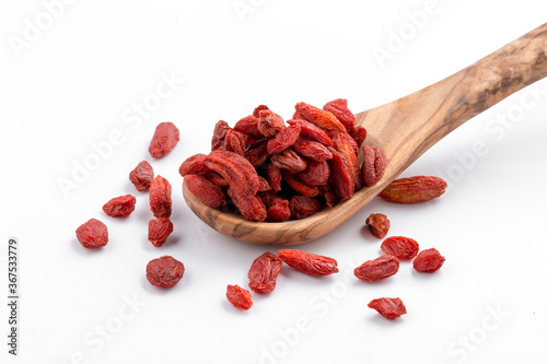 Isolated red dried barberries in the wooden spoon photo