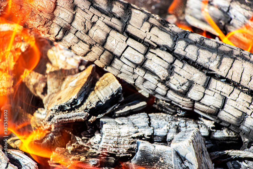 Burning firewood and coals in the grill. Close-up. Macro shooting. Burning fire. Grilling meat. Coals for frying Burning firewood and coals in the grill. Close-up. Macro shooting. Burning fire. Grilling meat. Coals for frying