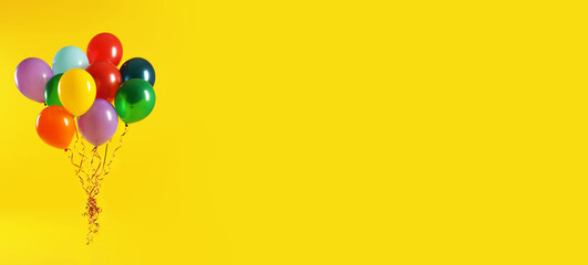 Bunch of bright balloons on yellow background, space for text. Banner design