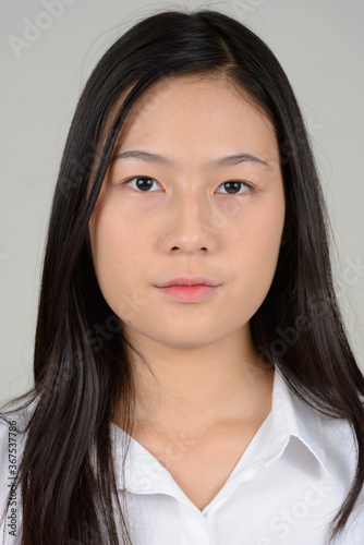 Portrait of young beautiful Asian businesswoman against white background
