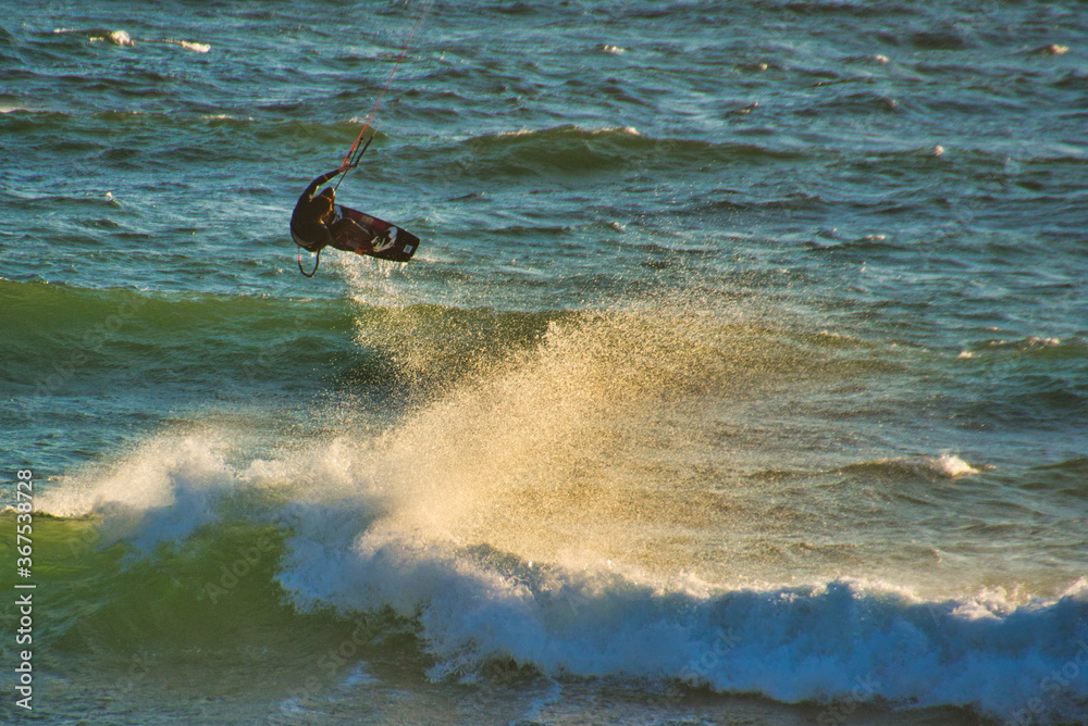 Fototapeta premium Kite surfer in the waves on Blouberg Beach, Western Cape, South Africa