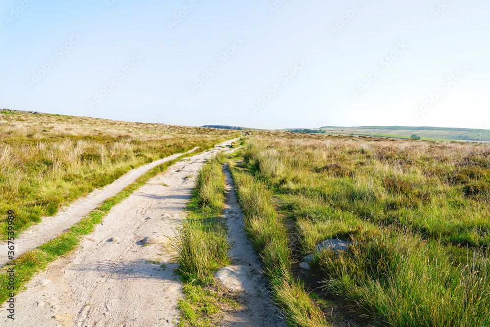 Wide dirt road going across Derbyshire moorland