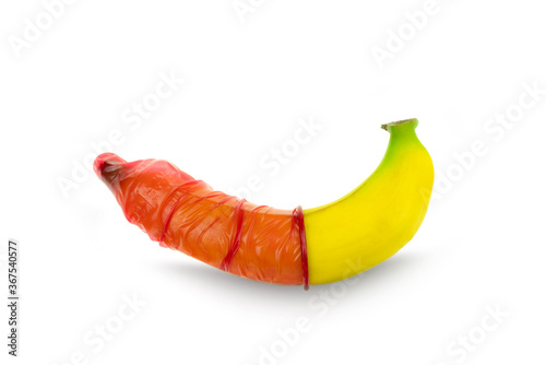 Red condom wear a banana on a white background concept safe sex prevention of sexually transmitted diseases and contraceptive