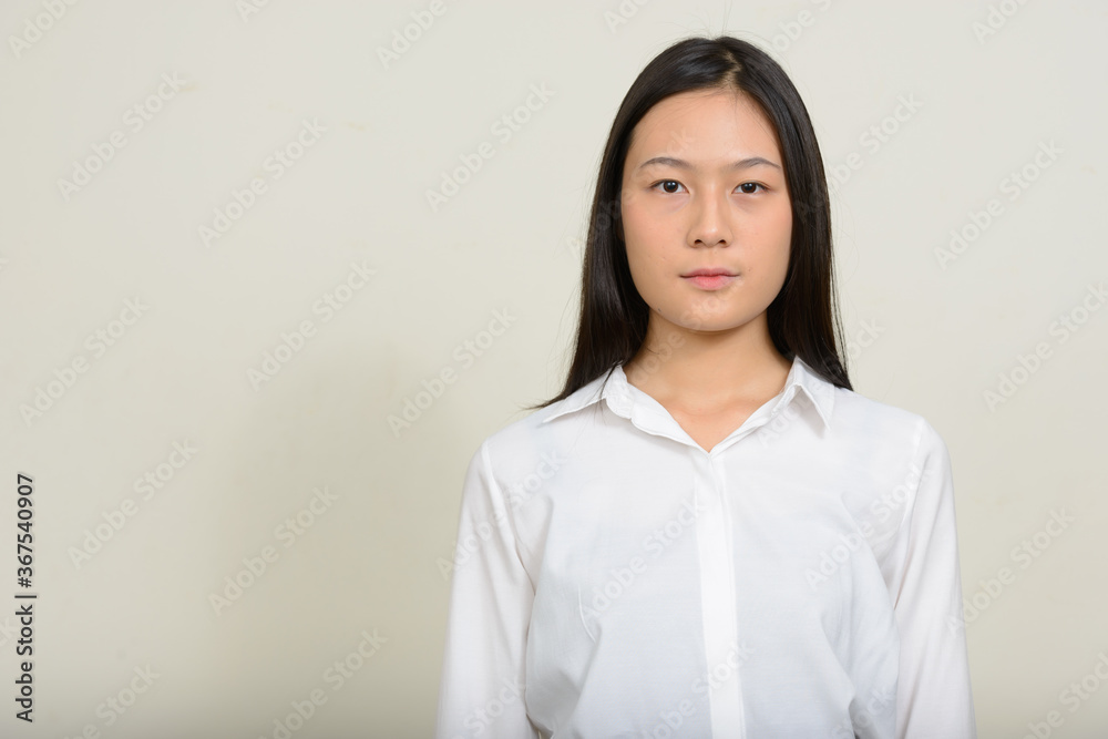 Portrait of young beautiful Asian businesswoman against white background Portrait of young beautiful Asian businesswoman against white background