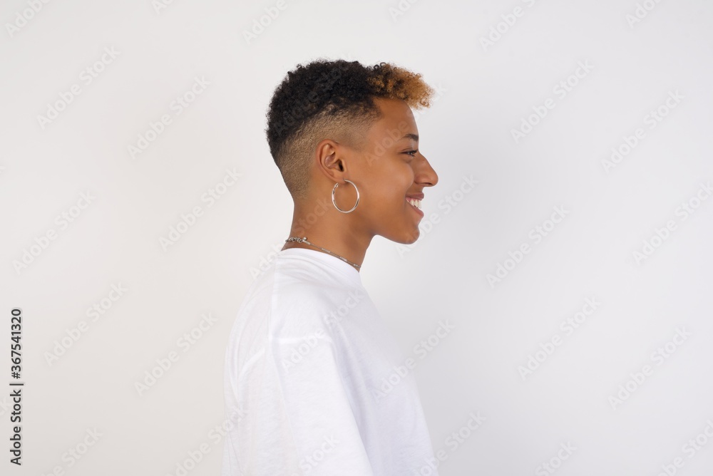 Profile of smiling woman with healthy pure skin, has contemplative expression, ready to have outdoor walk, isolated over white studio wall with copy space Profile of smiling woman with healthy pure skin, has contemplative expression, ready to have outdoor walk, isolated over white studio wall with copy space