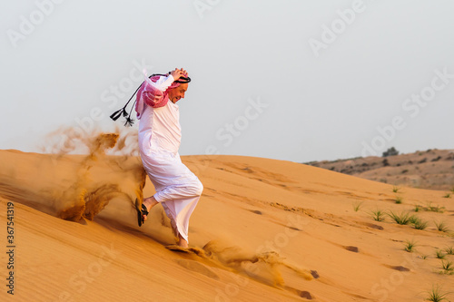 Portrait of Arabic man on a middle of yellow desert.