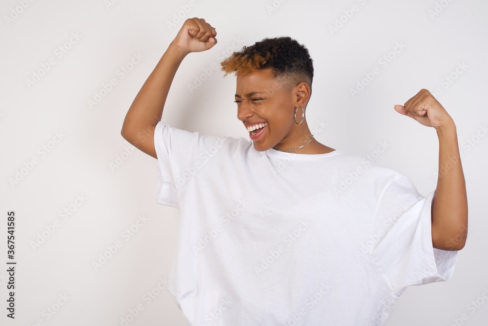 Yes I am winner. Portrait of charming delighted and excited caucasian female student raising up fist in triumph and victory smiling achieving success grinning from delight. Yes I am winner. Portrait of charming delighted and excited caucasian female student raising up fist in triumph and victory smiling achieving success grinning from delight.