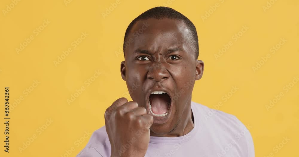 Portrait of furious black man screaming and shaking fist