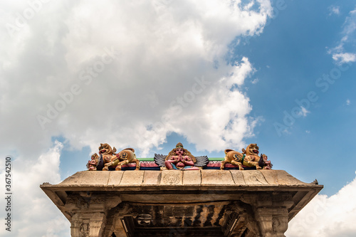 A colorful mandapa of an ancient Hindu temple in Srirangam with blue sky and white clouds. photo