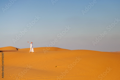 Portrait of thirsty Arabic man on a middle of yellow desert.