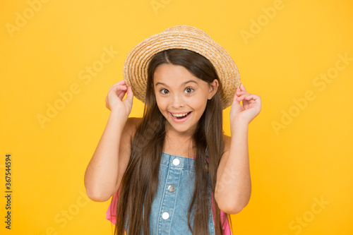 Good vibes. Portrait of happy cheerful girl in summer hat yellow background. Beach style for kids. Little beauty in straw hat. Fancy vacation outfit. Teen girl summer fashion. Summer holidays
