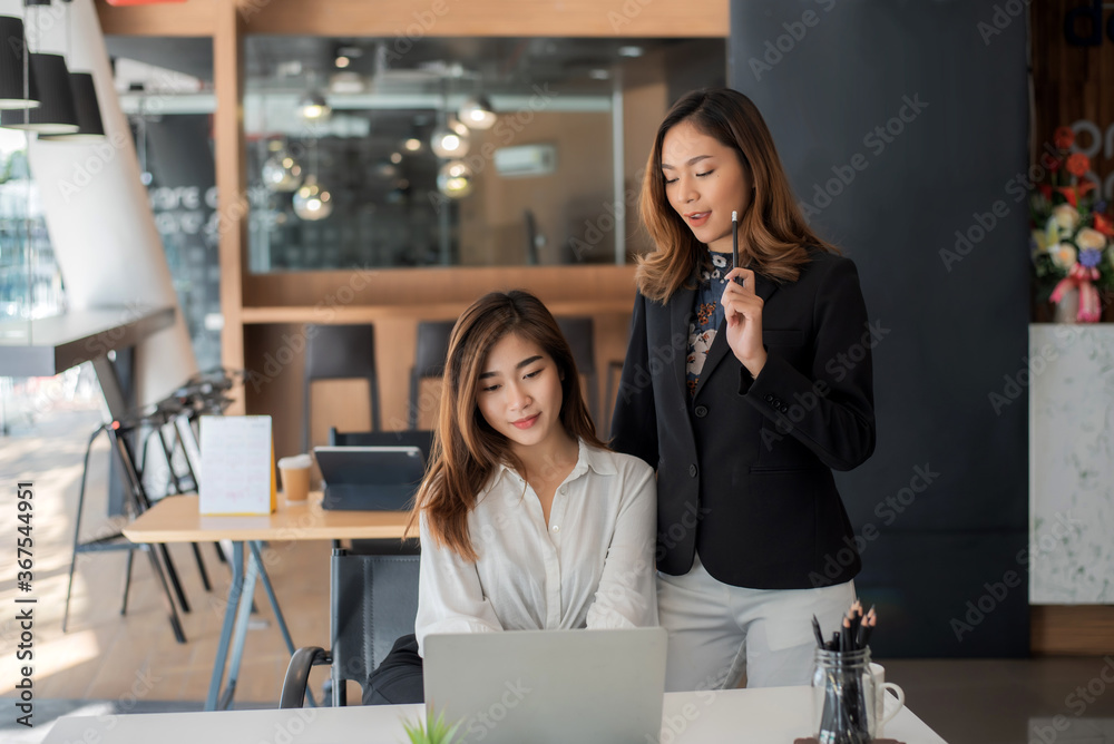 Two young asian businesswoman talking and working together at office.