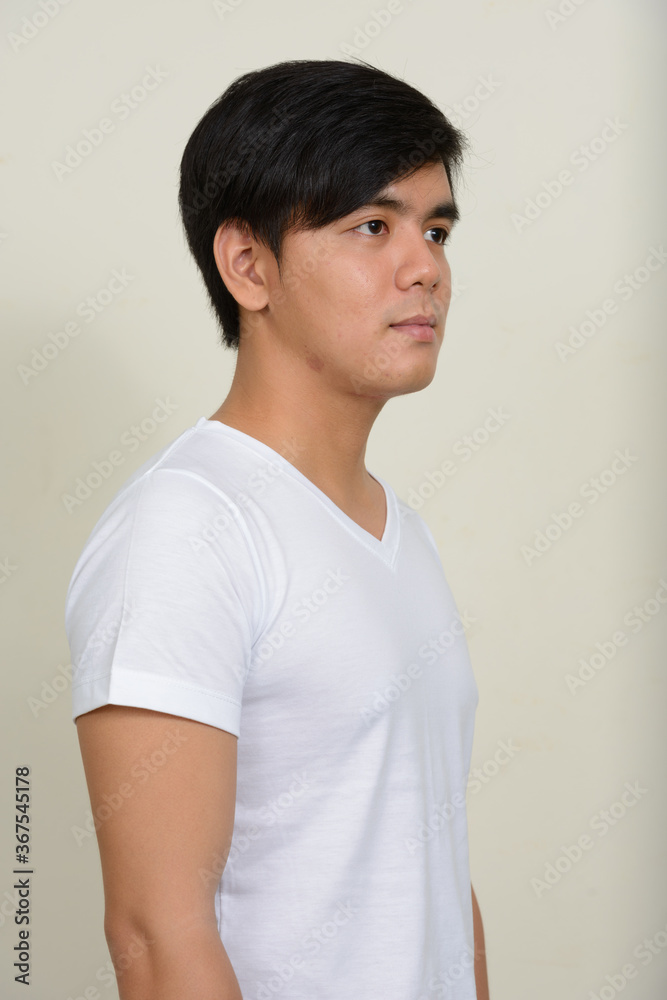 Obraz premium Portrait of young handsome Asian man against white background