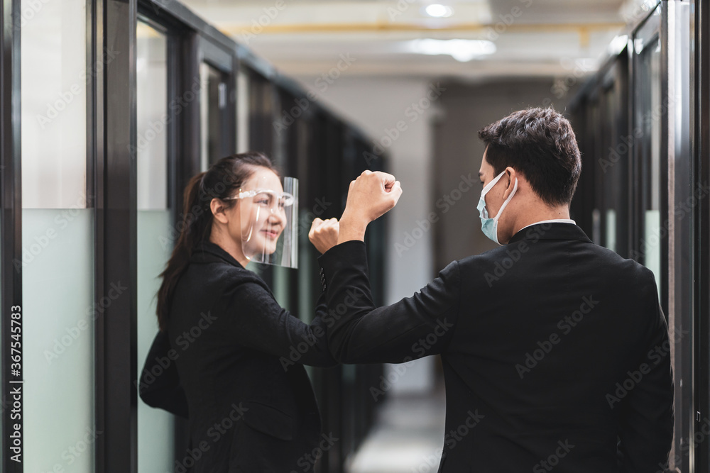 Asian businessperson in face mask new normal greeting by elbow bump Asian businessperson in face mask new normal greeting by elbow bump