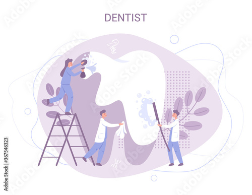Group of small dentists in uniform treat giant tooth using medical photo