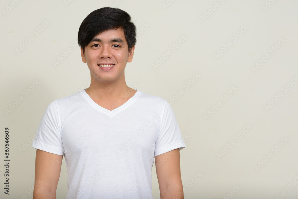 Portrait of young handsome Asian man against white background Portrait of young handsome Asian man against white background