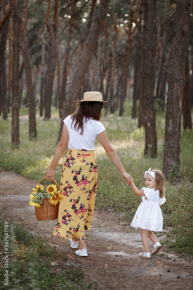 Fototapeta premium mother and daughter on a walk in the woods in the summer