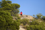 A man with a red shirt walks in the mountains of Finestrat-Spain. 