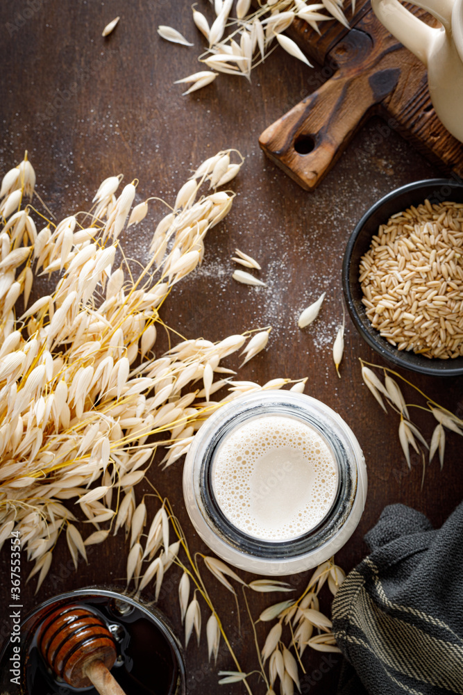 Vegan oat milk in glass bottle and ingredients for cooking. Healthy vegetarian non-dairy drink or beverage. Alternative milk Vegan oat milk in glass bottle and ingredients for cooking. Healthy vegetarian non-dairy drink or beverage. Alternative milk