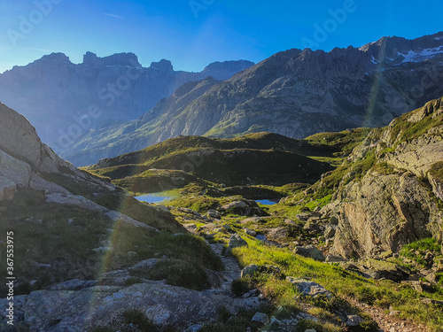 górskie jeziora otoczone wysokimi grzbietami góry, na które pada letni promień słońca © Malgorzata