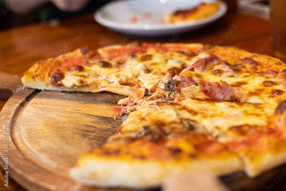 Close up pizza on woodden plate.