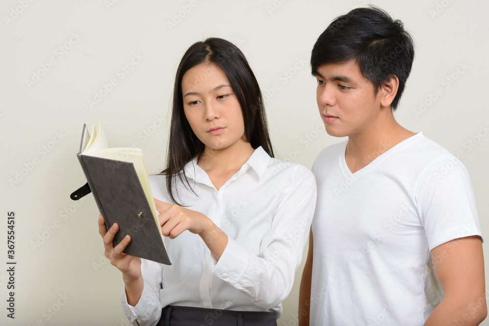 Portrait of young Asian couple together against white background Portrait of young Asian couple together against white background