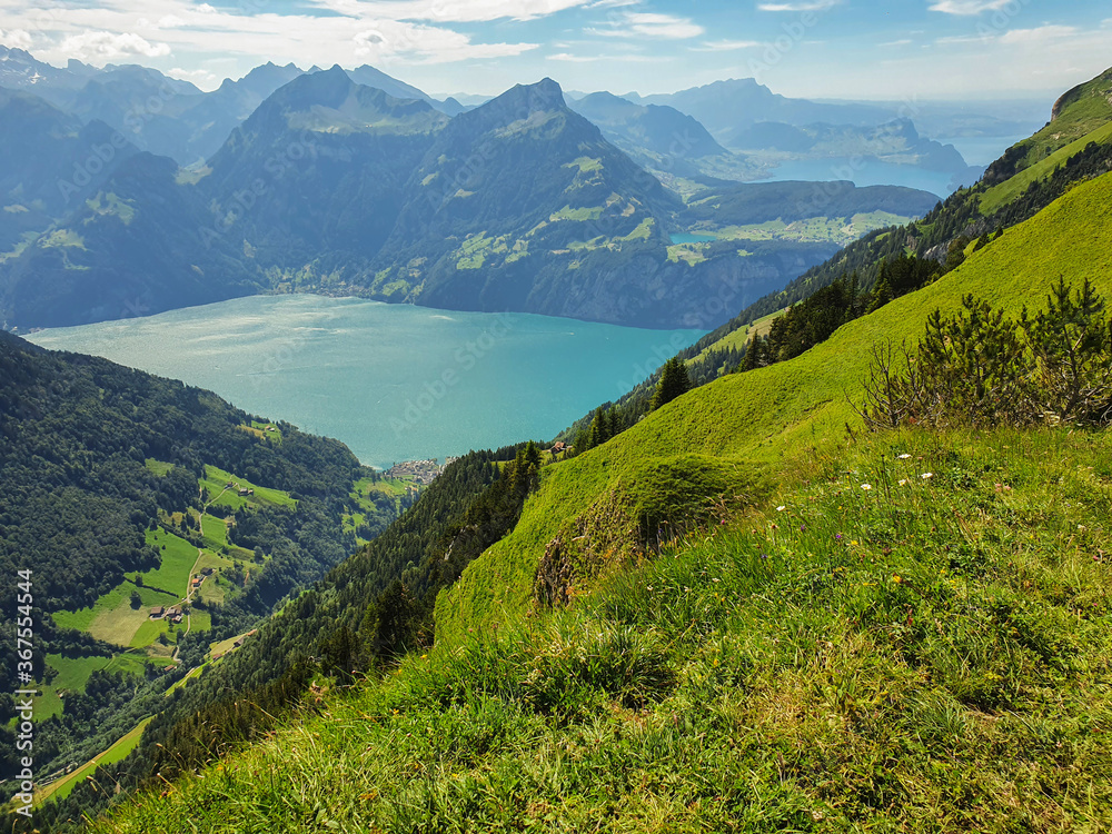 Widok na alpejskie jeziora otoczone wysokimi ośnieżonymi szczytami - obrazy, fototapety, plakaty 