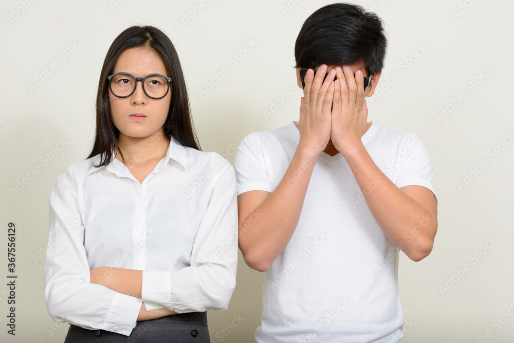 Portrait of young Asian couple together against white background Portrait of young Asian couple together against white background