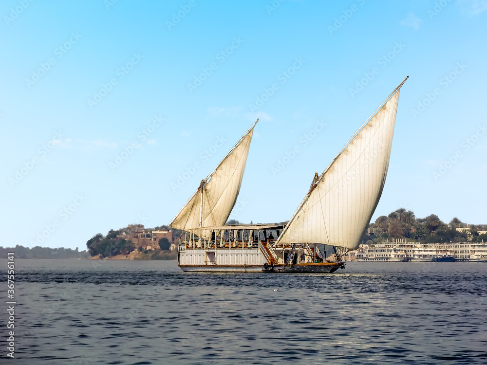 Obraz premium A sailing boat traveling on the river Nile at Luxor, Egypt in summer