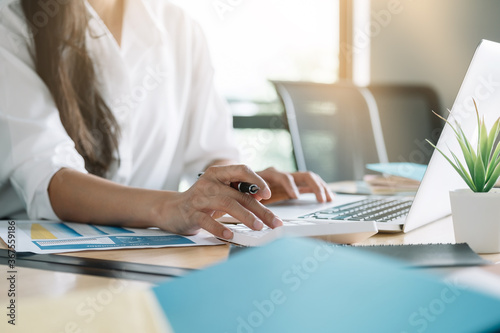 Close up of business woman or accountant working on calculator to calculate business data  accountancy document and laptop computer at office  business concept