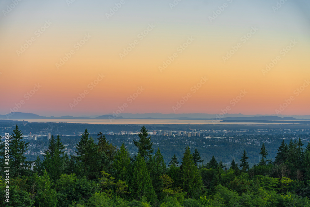 Panoramic sunset view from Burnaby Mountain patio garden across Fraser Valley to Strait of Georgia and Gulf Islands beyond
