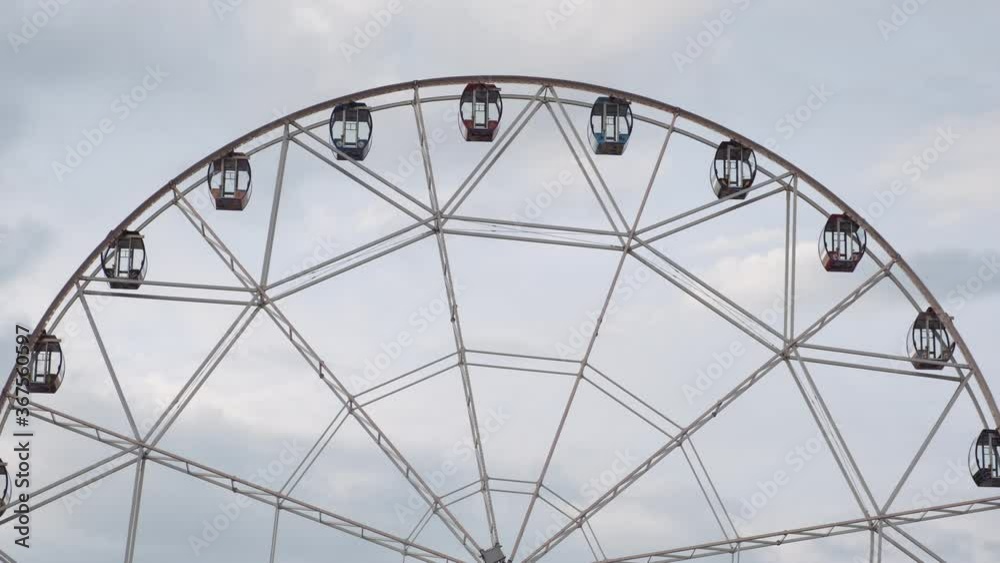 Ferris wheel Illuminated spinning on background of sky with clouds Ferris wheel Illuminated spinning on background of sky with clouds