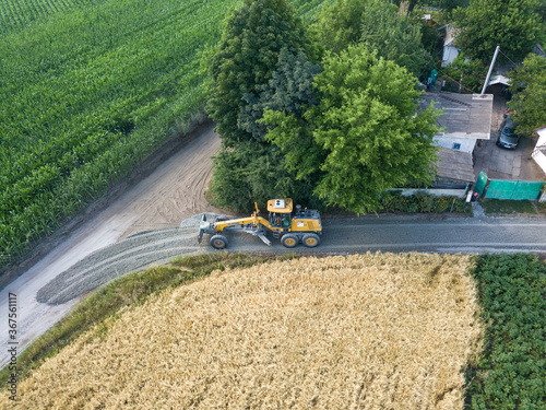 Aerial drone view. A grader on a rural street in Ukraine.
