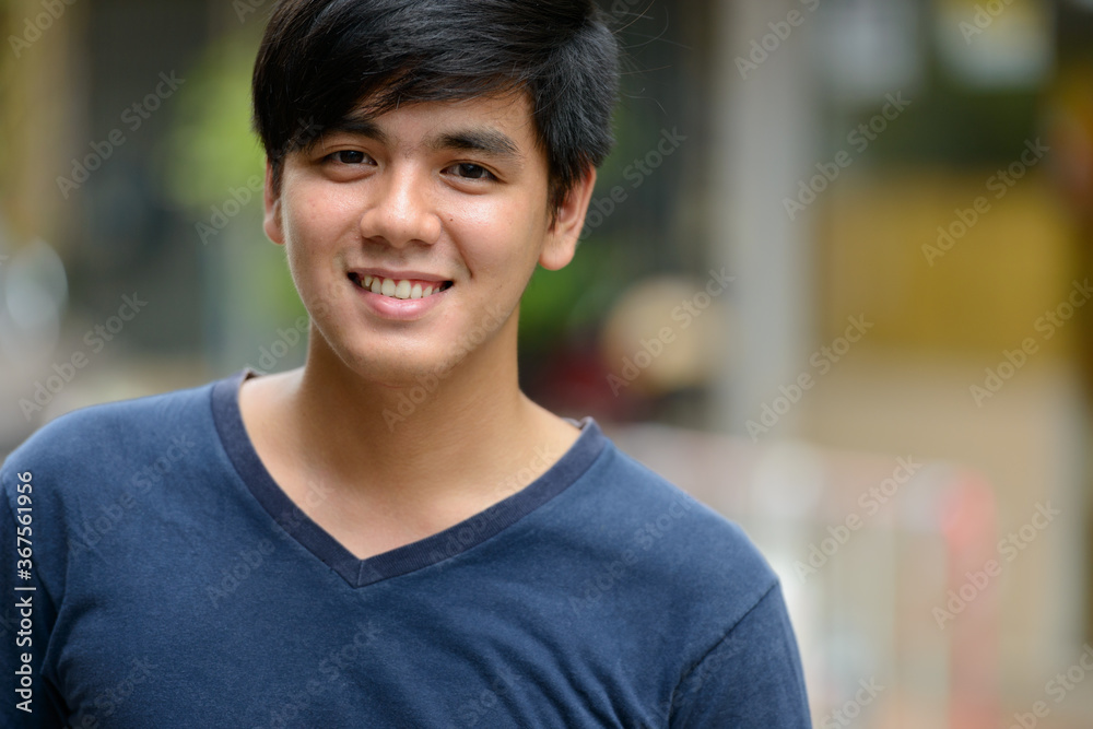 Portrait of young handsome Asian man outdoors Portrait of young handsome Asian man outdoors