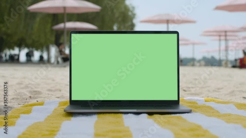 Remote work lifestyle. Working from the beach. Green screen laptop computer sitting on beach blanket.4K and HD. Download the preview for free.
