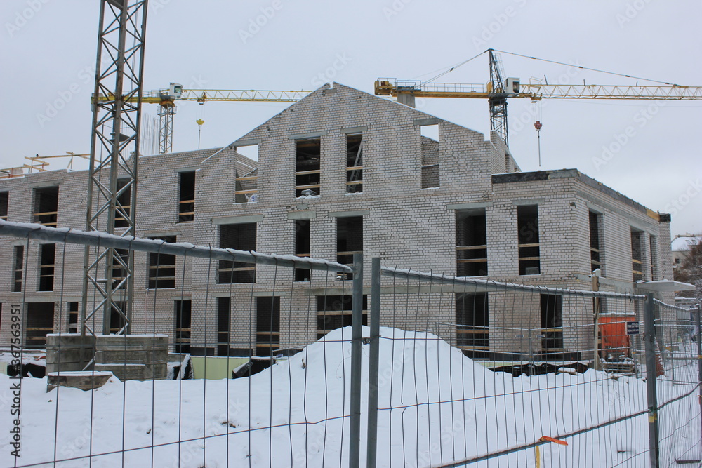 White brick building under construction in winter White brick building under construction in winter