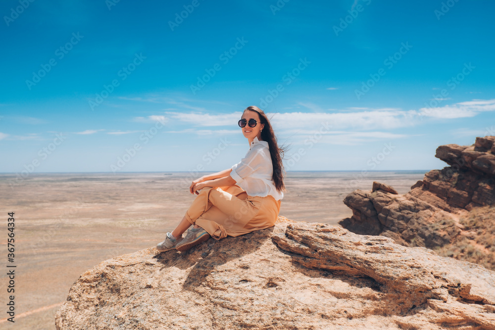 Beautiful woman in a dress on the mountain. The girl at the top of the mountain looks into the distance. Beautiful woman in a dress on the mountain. The girl at the top of the mountain looks into the distance.