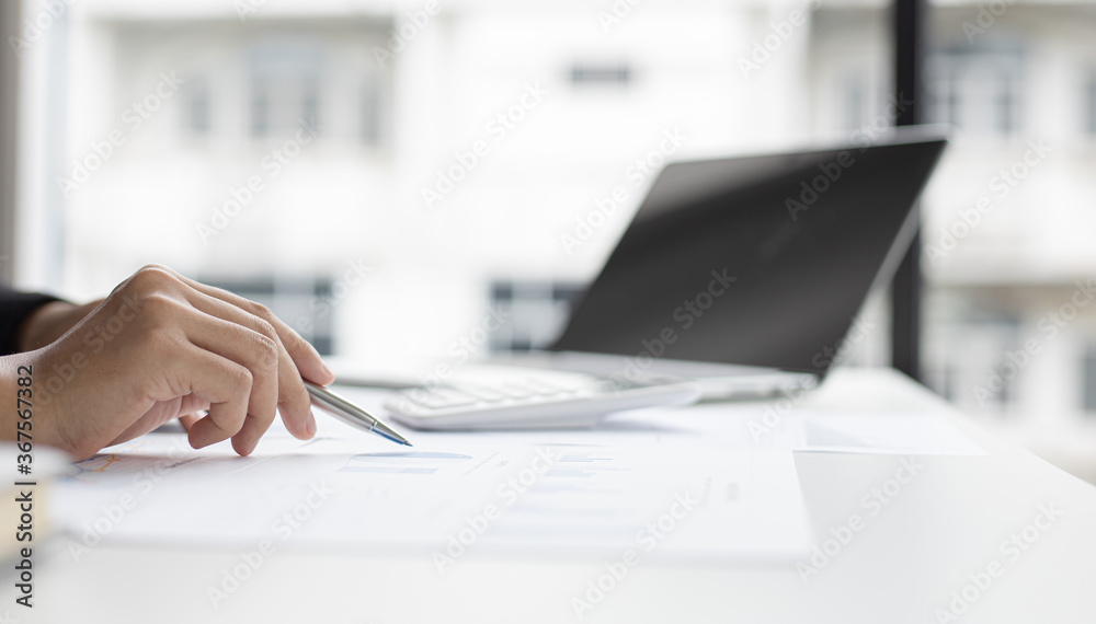 Asian woman is working on finances on her desk.
